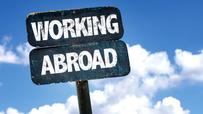 Working Abroad sign with sky background