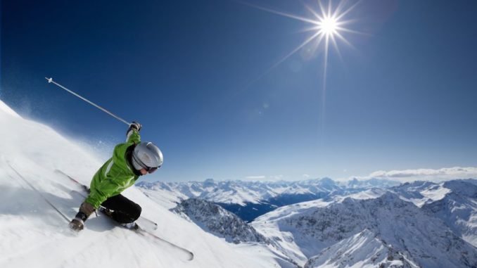7671830 - female skier on downhill race with sun and mountain view.